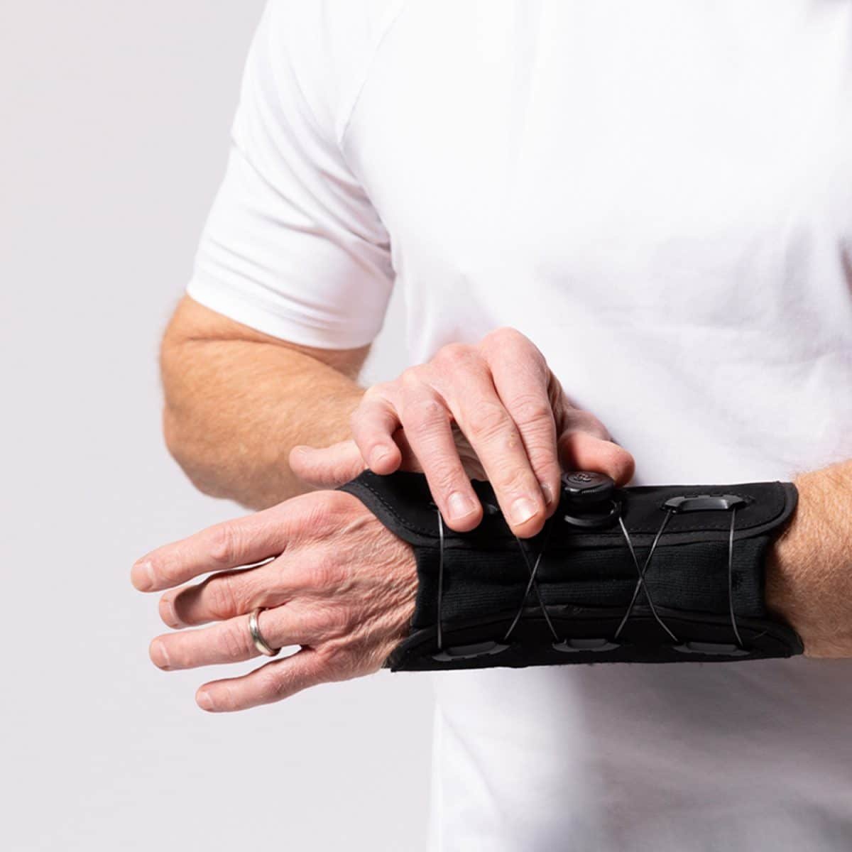 A man wearing an ARYSE METFORCE WRIST brace on a white background.