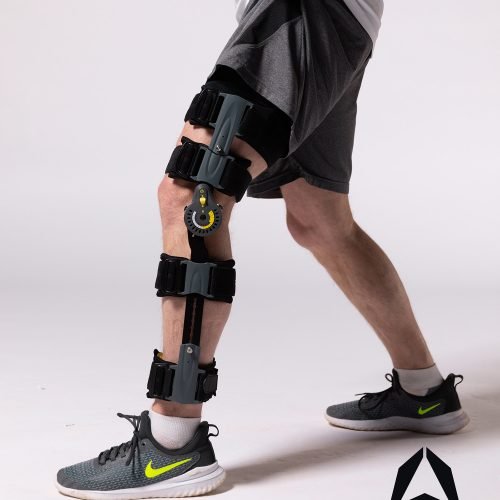 A man wearing a TRU-RANGE+ POST-OP KNEE brace.