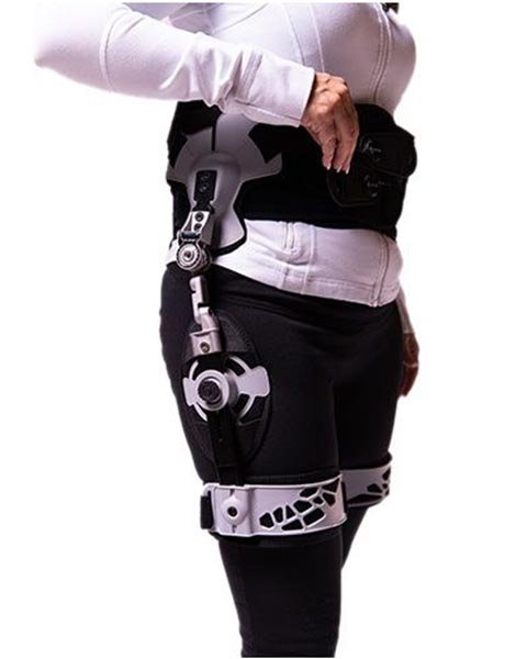 A woman wearing a harness with a device attached to it.