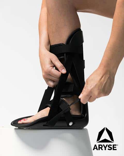 A woman is putting on an ankle brace from ARTIK Medical Supply.