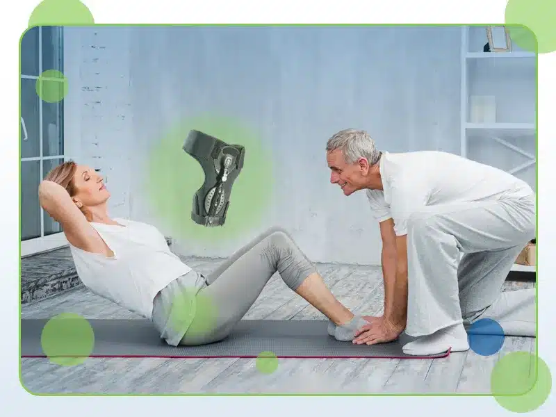 An older woman performs sit-ups on a mat while a man holds her feet. An image of a knee brace is superimposed above them.