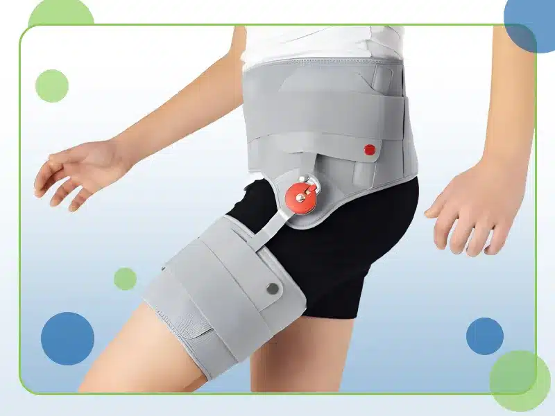 A person is wearing a leg and hip brace with adjustable straps and a circular adjuster on the hip section.